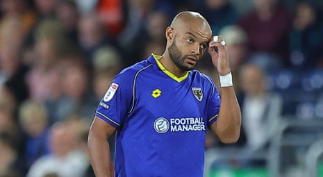 AFC Wimbledon defender Ryan Johnson gifted all three points to Luton Town by looping a defensive header over his own goalkeeper, Nathan Bishop, and into the back of the net at Kenilworth Road.