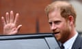Prince Harry waves by a car door.