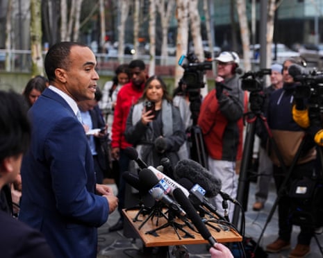 a man in a suit speaks to a crowd from a podium