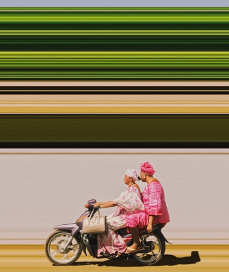 Two women in dresses on a motorbike, one in pink, handbag on handlebar, with green lines above and behind them