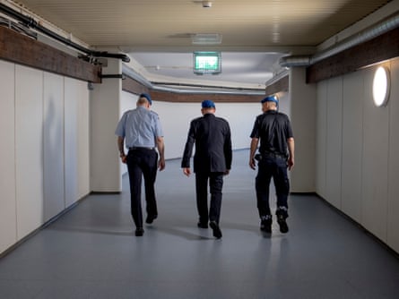 Three men, members of the Norwegian civil defence service, walking in a tunnel under a school in Oslo, Norway.