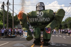 A green gorilla-type construction is set on fire by the students. One its front are the words ‘50 años de impunidad’ (50 years of impunity)
