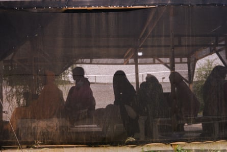 People sitting in a tent, seen in silhouette