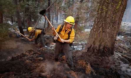 Firefighters Stephanie Lockhart and Dustin Peters of North Tahoe Fire break up smoldering areas after the Caldor fire moved through the area, in South Lake Tahoe, California, on Wednesday.