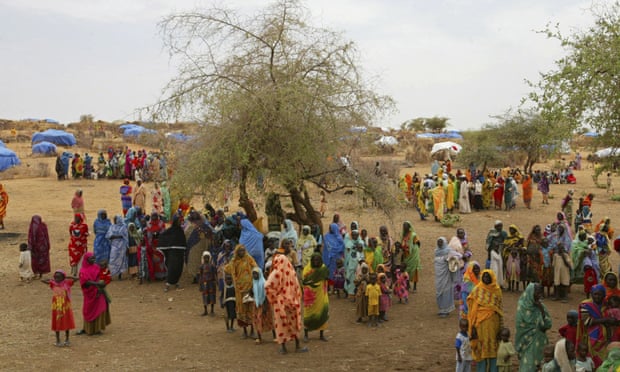 Dozens of women displaced by violence in Darfur gather in a refugee camp in 2004.