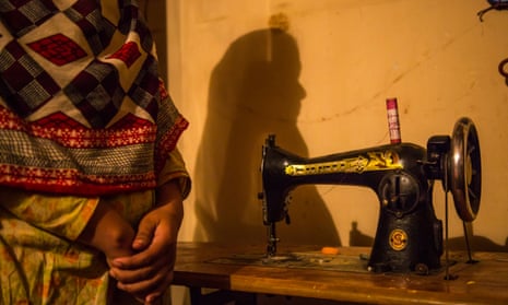 A garment worker, not fully pictured, next to a sewing machine