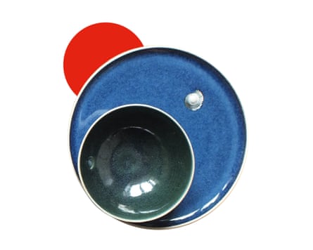 A small ceramic bowl placed on top of a larger ceramic plate with a shell pressed into it.