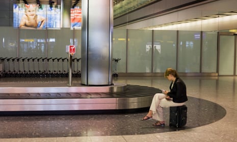 Lone woman awaiting her luggage at Heathrow terminal 5