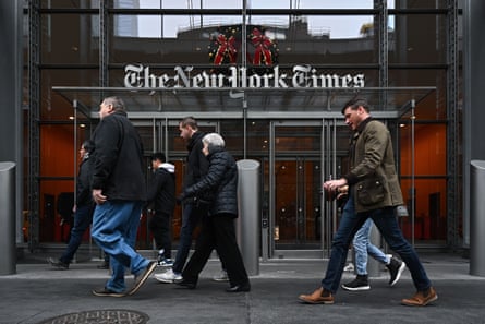 people walk in front of doors with ‘new york times’ logo over them