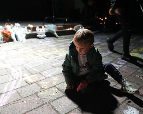 A four-year-old drawing with chalk on the ground