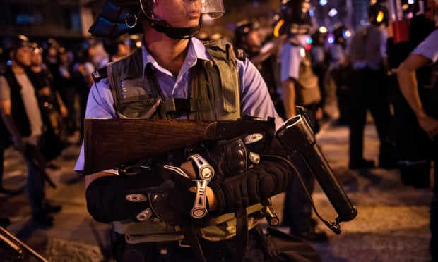 A Hong Kong riot police officer carries supplies to the front line during the clash with protesters.