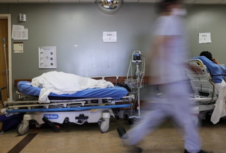 A patient lies on a stretcher in the hallway of the overloaded emergency room at Providence St Mary Medical Center in Apple Valley, California.