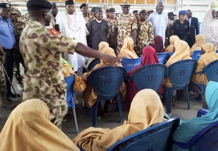 The girls who were kidnapped and released are seated during a hand over to government officials in Maiduguri.