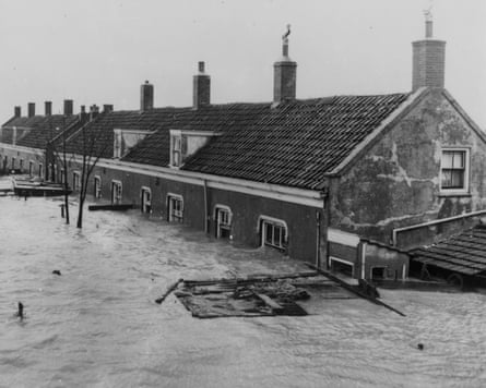 Black and white picture of row of houses with flood water nearly up to the roofs