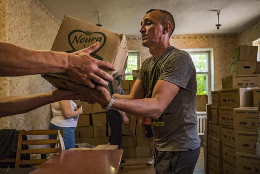A volunteer unloads boxes of humanitarian aid in Kostiantynivka, Donetsk.
