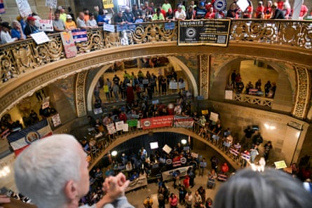 people with signs fill a government building