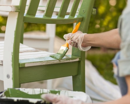 Worker paints garden furniture green. Renewing, Renovation Wooden Garden Furniture