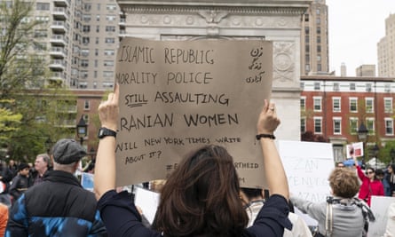 A woman attends a rally in New York and holds a sign that reads: ‘Islamic Republic, morality police still assaulting Iranian women’