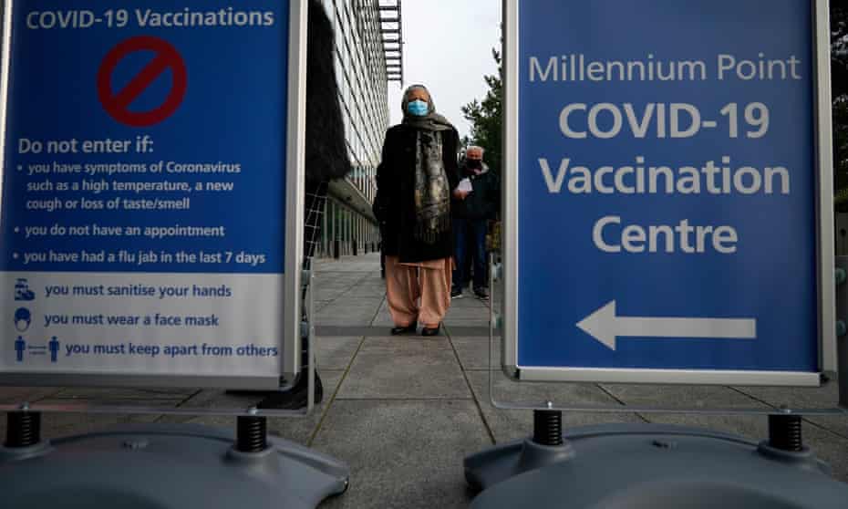 People queue outside an NHS Covid-19 vaccine centre in Birmingham