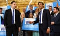 Rishi Sunak makes a pointing gesture with his right hand as he speaks in front of Tory party supporters holding signs saying 'Vote Conservative'