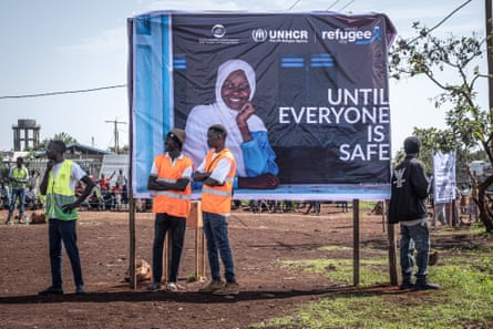 A poster featuring a woman and the phrase ‘until everyone is safe’, with a few men in hi-vis standing around it