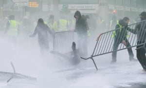 Police use water spray to disperse protesters wearing yellow vests in Brussels, Belgium.