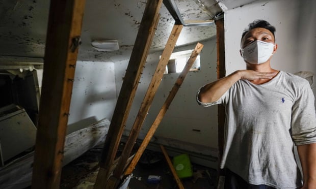 Danny Hong shows where the water reached up to him and the damage in his basement apartment on 153rd St in the Flushing neighborhood of Queens, New York, on Thursday.