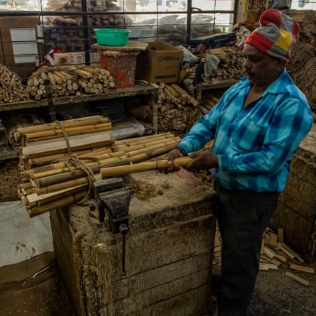 In the factory of Sanspareils Greenlands, a worker assembles the different parts of the handle of a cricket bat, made up of sections of cane wood sawn lengthways and then glued back together. Cork and/or rubber are glued between the different slices to absorb the shock of the bats.
