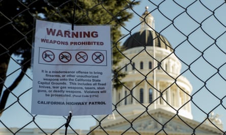 A sign reads ‘Warning weapons prohibited’ on a temporary fence outside the state capitol in Sacramento, California, on 17 January.