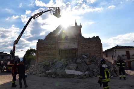 A member of the emergency services is lowered into a church to retrieve artefacts in San Lorenzo a Flaviano, Italy