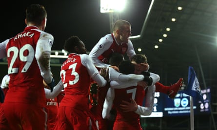 Arsenal players celebrate with Alexis Sánchez after his free kick deflected in off West Brom’s James McClean.