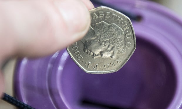 A coin is dropped into a charity collection container in London.