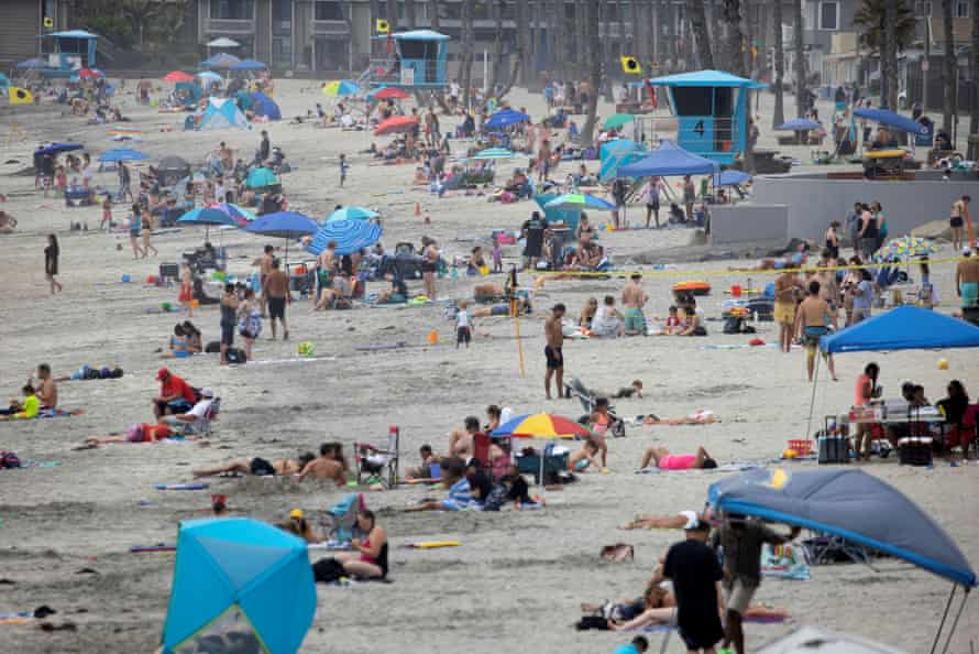 Few people wear masks as they gather at the beach in Oceanside last week.