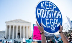 a protester holds a blue and white sign that reads 'keep abortion legal'