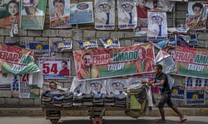 Campaign posters are seen along a street in Quezon city, Philippines, ahead of midterm elections seen as a referendum on Rodrigo Duterte’s drug war.