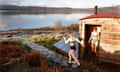 Both in sports bikinis, Rosie Barge is wearing Neoprene socks and gloves and walking on a stone path towards Loch Fyfe, and Hailey O’Hara is standing at the doorway of a wooden sauna