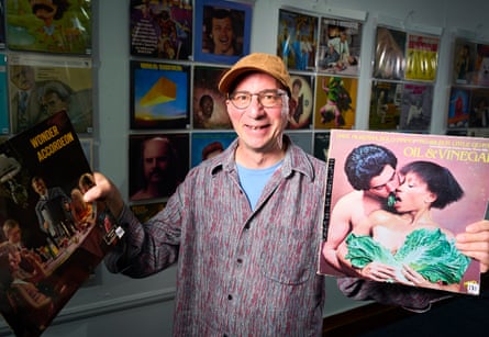 Steve Goldman holding two album covers, one depicting a couple kissing with chard in their mouths
