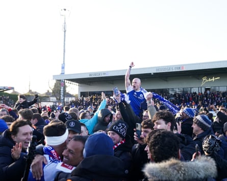Macclesfield’s Josh Kay celebrates with supporters amid a pitch invasion at the final whistle