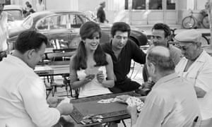 Raquel Welch plays cards with locals in Saint-Tropez during a break in filming the crime drama the Biggest Bundle of Them All, 1968