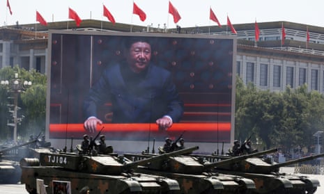 A billboard of President Xi Jinping and military vehicles