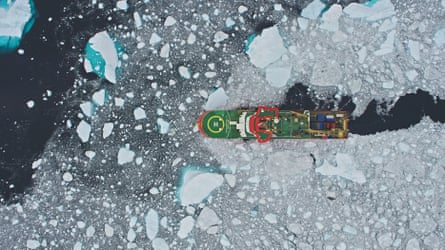A ship seen from above leaving a clear trail through ice as it sails towards ice-free water