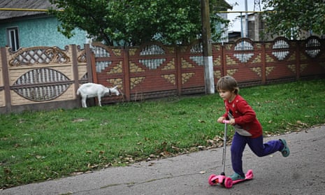 Tetyana, 6, rides her kick-scooter on an empty street in the recently liberated village of Vysokopillya, Kherson region