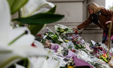 Members of the public lay flowers on the steps of the French embassy in London.