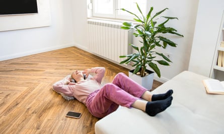 Young woman lying on her back with her legs elevated on a sofa
