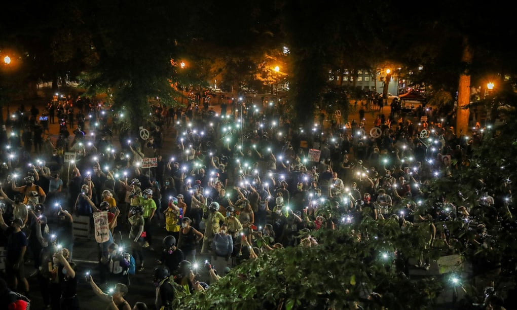 People shine cellphone flashlights during a demonstration against racial inequality and police violence in Portland, Oregon Wednesday.