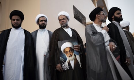 Shia clerics attend a protest against the revocation of the citizenship of prominent Bahraini cleric Sheikh Isa Qassim (shown in portrait).