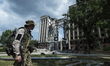 A Ukrainian serviceman in front of the destroyed headquarters of the Mykolaiv regional military administration in southern Ukraine after a Russian strike