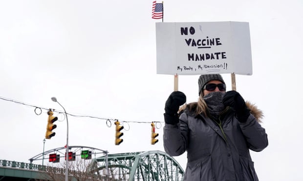 A person holds a sign at a rally against coronavirus vaccine mandates in Buffalo, New York.
