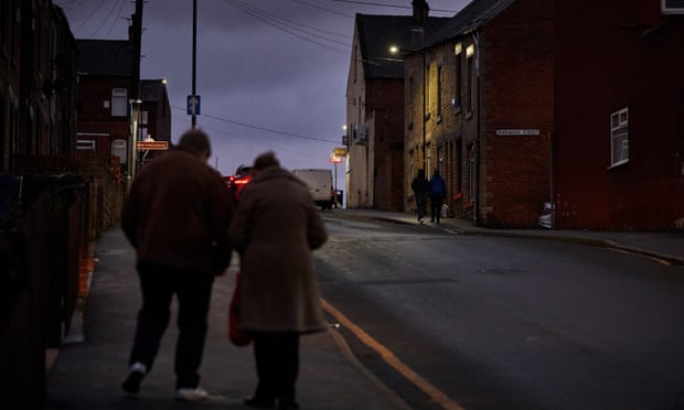 People walking down a street in fading light