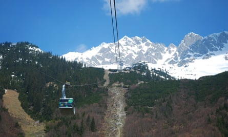 cable car with snowy mountains above